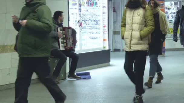 Guy student zarabia pieniądze grając na instrumencie muzycznym w tunelu metra w Mińsku, Białoruś 01.18.19. Ubóstwo i nędza z bayjskim akordeonem. Praca w niepełnym wymiarze godzin na opłacenie studiów wyższych — Wideo stockowe