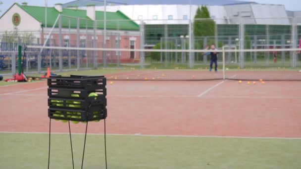 子供たちは夏にテニスコートでテニスをする。コーチがテニス、背景、スローモーションでスポーツをする — ストック動画