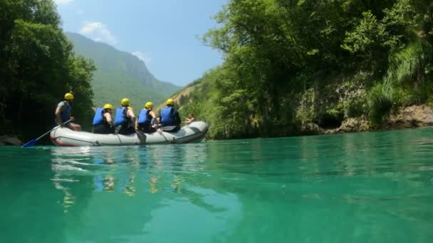 Grupo de turistas en un barco navegando a lo largo de un río de montaña Tara durante el rafting antes de rápidos extremos. Programa de entretenimiento Montenegro. Agua cristalina, hermoso paisaje natural con montañas — Vídeos de Stock