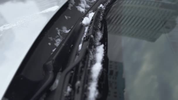Κοντινό παρμπρίζ ή υαλοκαθαριστήρας καλυμμένος με πάγο και χιόνι κατά τη διάρκεια της χειμερινής ημέρας. Κακός και κρύος καιρός. Δυσλειτουργία ή πρόβλημα με την αυτόματη. Χειροκίνητη βολή — Αρχείο Βίντεο