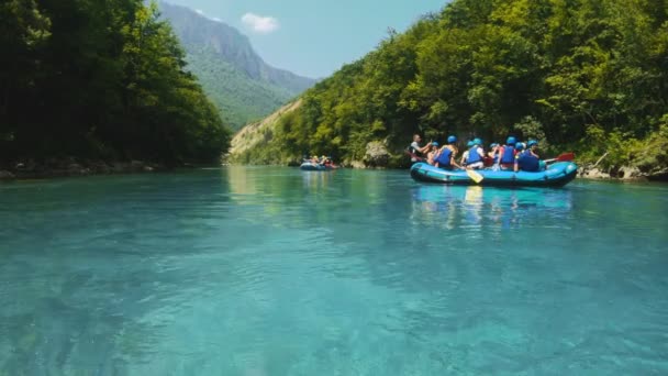 Група туристів на човні повільно мандрує гірською річкою Тара під час рафтингу перед екстремальними порогами. Програма розваг у Чорногорії. Кришталева чиста вода, мальовничий краєвид з горами. — стокове відео