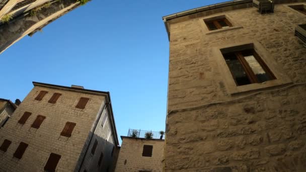 Casas de tijolos antigos de arquitetura veneziana e mediterrânea. Vista inferior e baixo ângulo de edifícios em Budva Montenegro. Como uma Itália ou Sicília. Panorama. Viagem turística e viagens. Movimento lento — Vídeo de Stock