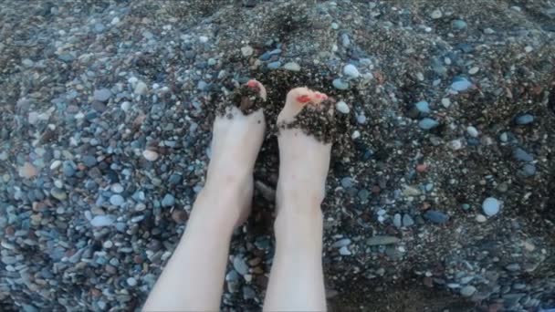 Female legs on the background of the beach on the sea of pebbles. Rest and relaxation, slow motion, vacation — ストック動画