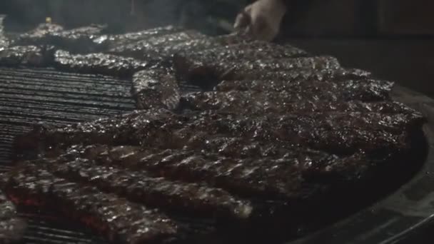Cooking delicious grilled ribs meat, background. Professional chefs cook fried juicy meat, slow motion — Stock Video