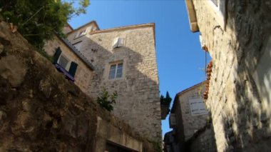 Karadağ 'ın tarihi Kotor kentinde taştan yapılmış güzel bir bina, güneşin arka planına karşı eski bir mimari yapı. Turizm Merkezi