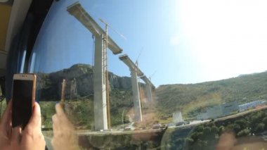 Turist otobüsünün penceresinden manzara. Karadağ 'da kanyonlar arasında ağır çekimde modern bir köprü inşa edildi