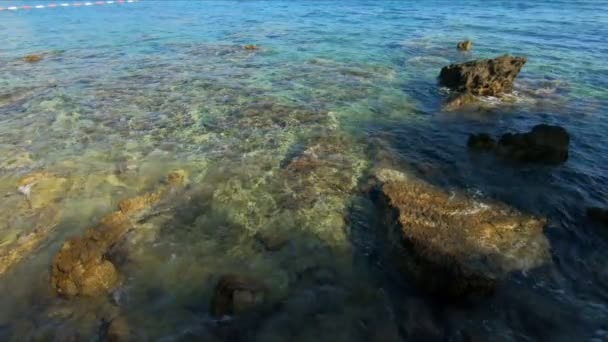 Vacker grönblå våg på havet, bakgrund. Vågen av havet tvättas av stora stenar på stranden, bakgrund. Avslappning och avslappning, slow motion — Stockvideo