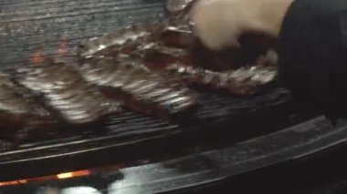 Restoran müzesinde ızgarada domuz pirzolası kızartma işlemi, geleneksel bir yemek, 4K. Aşçı ızgara domuz kaburgası yapar.