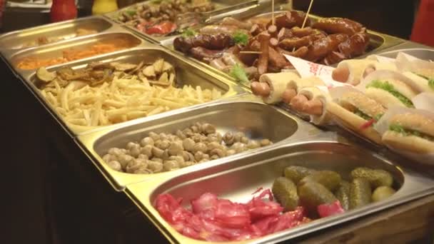 Hot dogs and burgers are on display, street food. Quick snack, fatty junk food. Mushrooms and fries, food to choose from — Stock Video