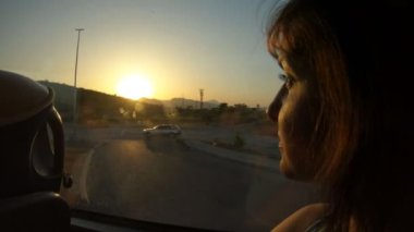 Beyaz güzel bir kız otobüs penceresinden dağ manzaralarına ve Karadağ 'ın doğasına bakıyor. Rahatlama ve gerçekçilik kavramı, gün batımı, yavaş çekim
