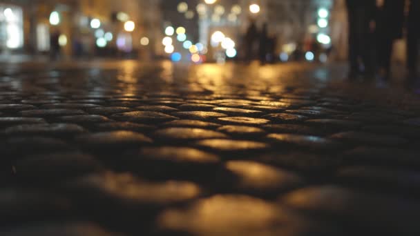 Cobblestone trotoar di kota dengan latar belakang lampu malam. Waktu malam, menyalin ruang — Stok Video