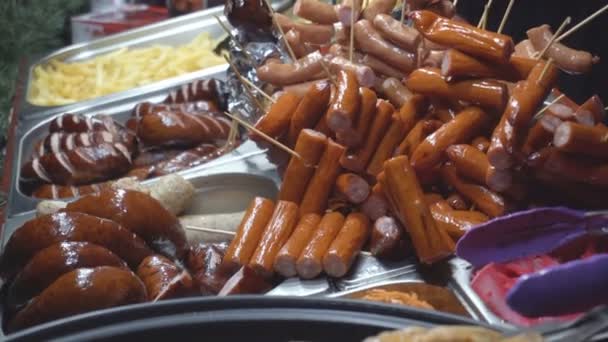 Comida de rua de salsicha e cachorros-quentes em uma janela de loja. Fast food para a ideia de hambúrgueres e batatas fritas, junk food, gordura — Vídeo de Stock