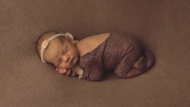 Μικρή όμορφη καυκάσιο κορίτσι σε κομψά ρούχα κοιμάται στο στούντιο και ποζάρει για μια φωτογράφηση, βρέφος — Αρχείο Βίντεο