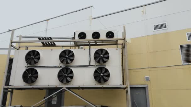 Grandi attrezzature condizionatore d'aria o sistema di ventilazione al di fuori del supermercato edificio o centro commerciale. Grande che si estende vicino al negozio. Le pale dei ventilatori girano ad alta velocità. Mid shot — Video Stock