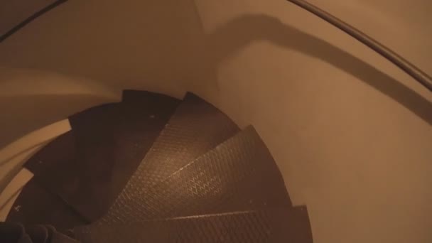 Un hombre baja por una escalera circular, fondo, primer plano, elemento de diseño, arquitectura antigua — Vídeos de Stock