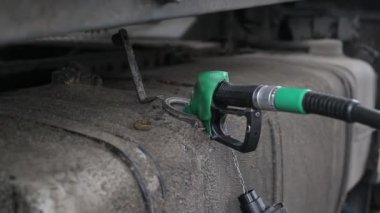 Bir kamyon şoförü kargo taşıyan bir kamyonda yakıt deposuna dizel yakıt dolduruyor. Artan akaryakıt fiyatları, akaryakıt ekonomisi, motor kamyonu kavramı
