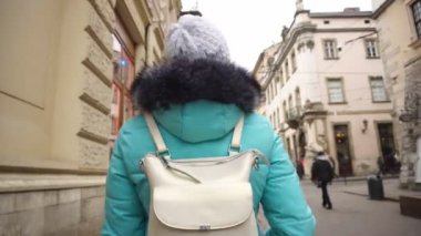 Kız turist Lviv şehrinde dar eski caddelerde yürüyor. Güzel mimari ve simgeler, arka plan, açık hava