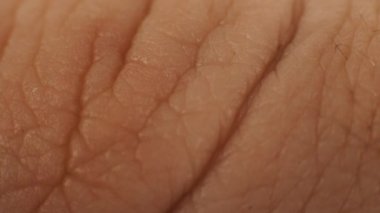 Makro, cilt, parmak uçlarında ve orta parmak kemiklerinde kırışıklıklar oluşturur. Beyaz, beyaz, beyaz bir erkeğin vücut parçaları. Hazine