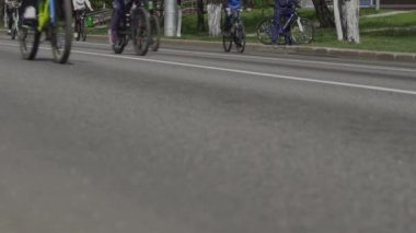 Bisikletçiler için yarış müsabakası. Şehirde toplu bisiklet gezileri. Bisiklet maratonu. Ana caddede bisikletleri olan vatandaşlar. Sporculardan oluşan bir sütun. Düşük açılı tekerler.