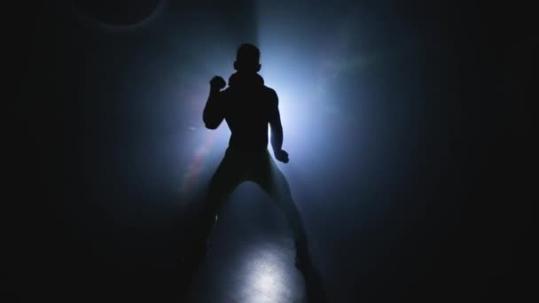 Hot muscular stripper like a macho shows performance alone. Man choreographer dances Striptease in silhouette in slowmo. Private erotic dance with torso. Male sexual body movements. Background light — Stock Video