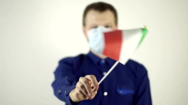 Virüse karşı yüzünde koruyucu maskeli bir adam İtalya bayrağını sallıyor. Ülke Koronavirüs Hastalığı Konsepti, COVID-2019, salgın hastalık