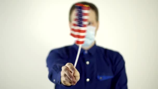 Ein Mann mit Schutzmaske vor dem Virus schwenkt die Flagge des Landes Amerika. Country Coronavirus Disease Concept, COVID-2019, Pandemie, USA — Stockvideo