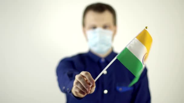 Ένας άντρας με προστατευτική μάσκα στο πρόσωπό του ενάντια στον ιό κουνώντας τη σημαία της χώρας της Ινδίας. Country Coronavirus Disease Concept, COVID-2019, πανδημία — Αρχείο Βίντεο