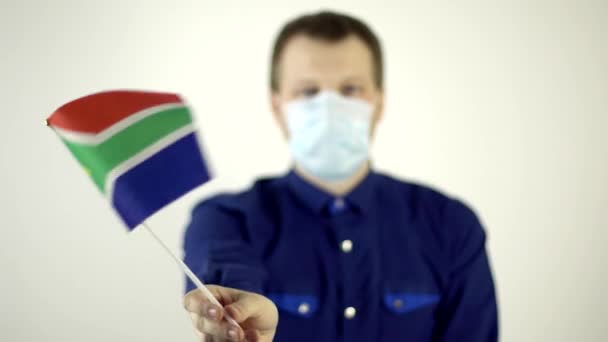 Un hombre con una máscara protectora en la cara contra el virus ondeando la bandera del país de Sudáfrica. País Concepto de Enfermedad por Coronavirus, COVID-2019, pandemia — Vídeos de Stock