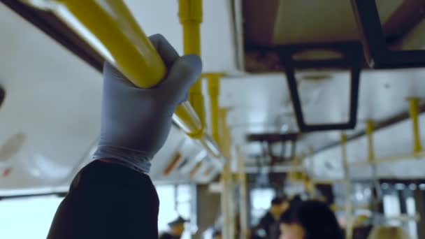 Un uomo cavalca in un trasporto pubblico e tiene un corrimano nel suo schizzo medico protettivo. Infezione da coronavirus e concetto di protezione epidemica, pandemia — Video Stock