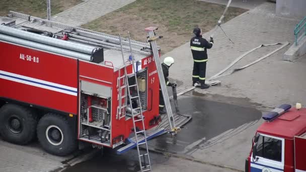 BOBRUISK, BÉLARO 27.02.19: Los bomberos de rescate preparan equipos contra incendios desde los camiones de bomberos para extinguir un incendio y evacuar a las personas — Vídeos de Stock