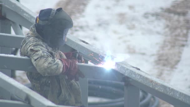 Працівник зварювальник в захисному шоломі зварює металеві поверхні, використовуючи електрод, промисловість. Будівництво будівлі, копіювання простору — стокове відео