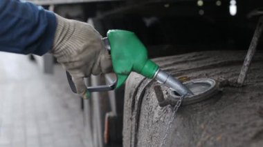 Bir kamyon şoförü kargo taşıyan bir kamyonda yakıt deposuna dizel yakıt dolduruyor. Artan akaryakıt fiyatları, akaryakıt ekonomisi, motor kamyonu kavramı