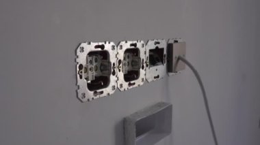 Yalıtımsız elektrik soketi ve 8P8C RJ45 vale konnektörü yenileme ya da onarım sırasında monte edilmemiş durumda. AC güç prizleri Europlug tip C CEE. Güvensiz, güvensiz ve tehlikeli bir durum.