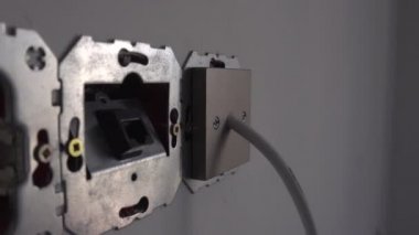 Ayrı olmayan AC güç soketi ve 8P8C RJ45 jack konnektörü, apartmanın yenilenmesi ve onarımı sırasında parçalanmış durumda. Avrupa Birliği tip C CEE. Güvensiz, güvensiz ve tehlikeli bir durum.
