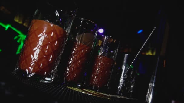 Skleničky s alkoholem Bloody Mary jsou na barové stoličce nebo na tabuli v nočním klubu. Mladý životní styl a relaxace v konceptu dovolených. Holandský úhel výstřelu — Stock video