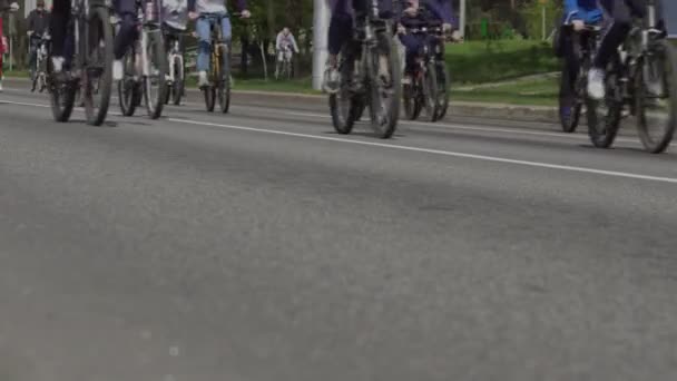 街で大量自転車に乗る。自転車マラソン。サイクリストのためのレース大会イベント。メインストリートに自転車を持っている市民。選手の列。車輪の低角度ショット — ストック動画