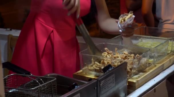 Női eladó intézi darab sült csirke eladó. Utcai ételek az esti piacon, csemege — Stock videók