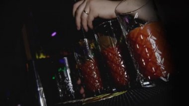 Barmen gece kulübünde alkollü kokteyl Bloody Mary ile karıştırır ya da karıştırır. Genç yaşam tarzı ve tatil konseptinde rahatlatıcı. Hollanda açılı el vuruşu