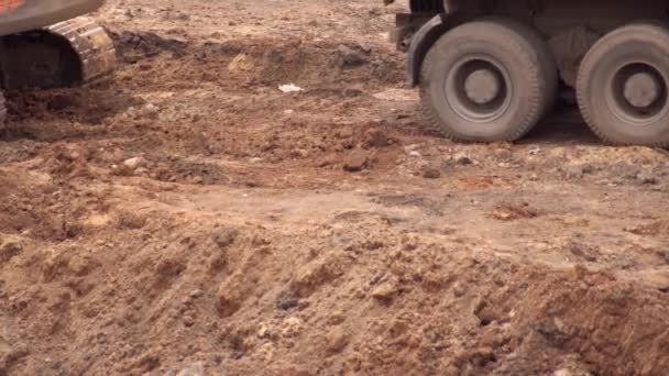 Um caminhão carregado com areia sai depois de carregar uma escavadeira com areia em um canteiro de obras, a indústria. Espaço de cópia — Vídeo de Stock