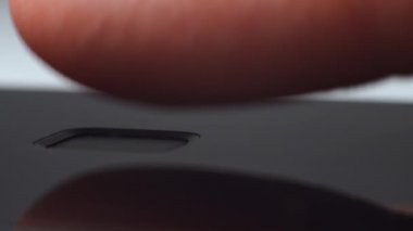 Parmak, akıllı telefonun kilidini açmak için parmak izi sensör tarayıcısına dokunuyor. Makro. Cep telefonu ve bilgi hırsızlığı kavramındaki kişisel verilerin güvenliği