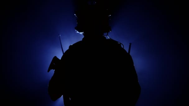 Military soldier in military equipment with a firearm in smoke on a blue background. Backlight, military operations. American army — Stock Video