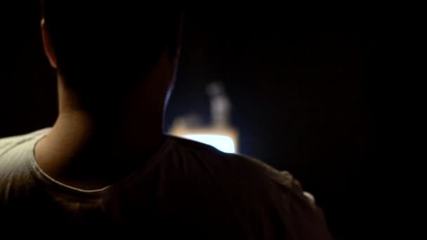 Gros caucasien dans un T-shirt sale manger de la malbouffe à la maison devant la télé, gros plan. L'obésité et les dommages de la nourriture, au ralenti 