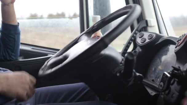 A kamionsofőr megdönti a kormánykereket, hogy elinduljon egy közúti vonaton. Kényelem és biztonság koncepció teherautó fülkében, kényelmes — Stock videók