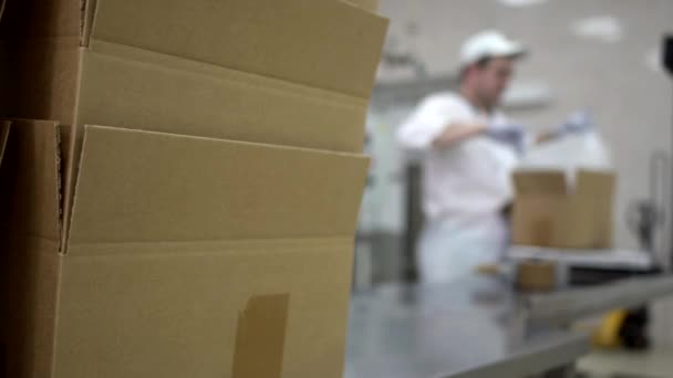 Un trabajador de una planta lechera pone mantequilla y cuajada glaseada en cajas. Producción de productos lácteos en la producción, exportación — Vídeos de Stock