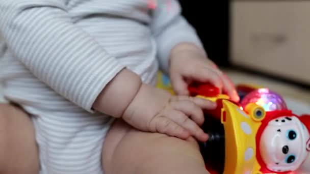 Pequeño niño hermoso se juega con juguetes en casa. Niño de 8 meses, caucásico. Grandes ojos marrones — Vídeo de stock