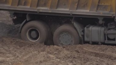 Bir inşaat kamyonu kumda durdu. Merkez diferansiyel kilit, arka plan, endüstri. Tekerlek tutuşu