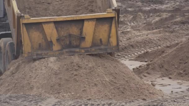 Caminhão em um canteiro de obras derrama areia de um corpo para a construção, indústria, fundo — Vídeo de Stock