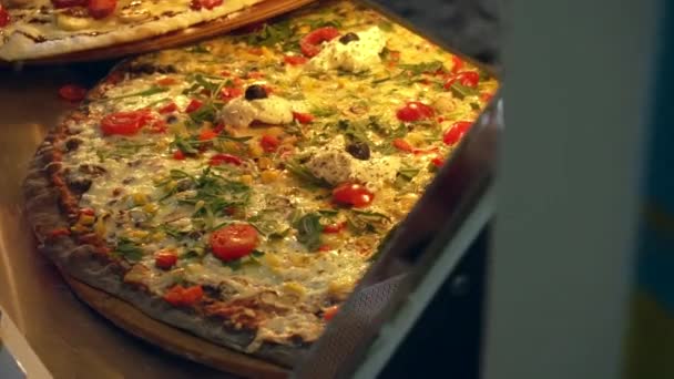 Уличная еда, вкусная пицца с помидорами и сыром лежит на окне, фон — стоковое видео