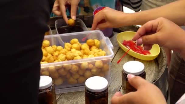Οι άνθρωποι δοκιμάζουν τραγανές μπάλες με μέλι, φαγητό του δρόμου, λιχουδιά, γλυκύτητα — Αρχείο Βίντεο