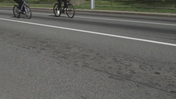 Massa fietstochten in de stad. Fietsmarathon. Wedstrijd evenement voor fietsers. Burgers met hun fietsen op de hoofdstraat. Een colonne atleten. Lage hoek schot van de wielen — Stockvideo